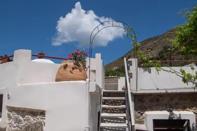 a pot on the side of a white building with stairs at Feneri Traditional House Apt 1- 20' from Elafonisi beach in Elafonisi