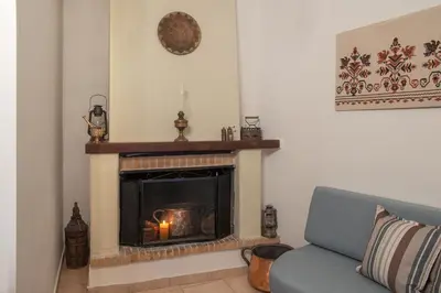 a living room with a fireplace with a blue couch at Feneri Traditional House Apt 1- 20' from Elafonisi beach in Elafonisi