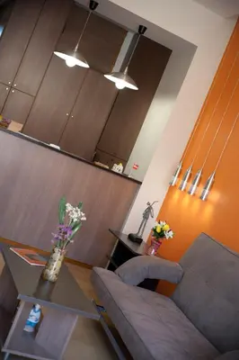 a living room with a couch and a table with flowers at Nikolas Suites in Kato Daratso