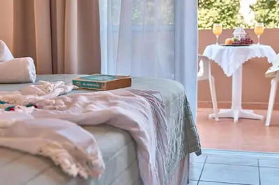 a bedroom with a bed with a book and a table at Solon Apartments in Maleme