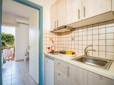 a kitchen with a sink and a bowl of fruit at Solon Apartments in Maleme