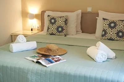 a hotel room with a bed with a hat and towels at Solon Apartments in Maleme