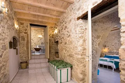 a stone walled hallway with a room with a bed at Trigono Luxury House in Kissamos
