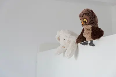 an owl stuffed animal sitting on a white background at WeCrete Apartments in Drapaniás