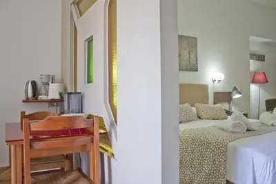 a bedroom with a bed and a table and a desk at Hotel Christina in Chania Town