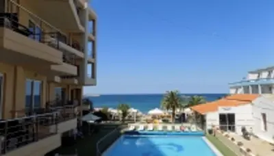a swimming pool with a view of the ocean at Hotel Christina in Chania Town