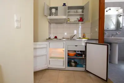 a kitchen with a sink and an open refrigerator at Nikos Apartments in Falasarna