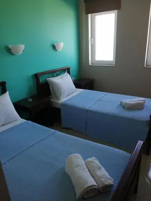 two beds in a room with two towels on them at Nikos Apartments in Falasarna