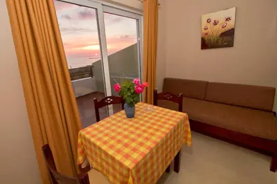 a room with a table and a couch and a window at Nikos Apartments in Falasarna