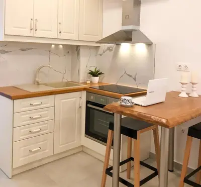 a kitchen with a laptop on a wooden table at Stelisia Rooms in Chania Town