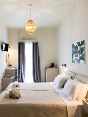 a bedroom with a large bed with a chandelier at Stelisia Rooms in Chania Town