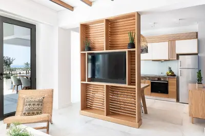 a living room with a television in a wooden entertainment center at Blue Island Luxury Apartment in Kato Daratso