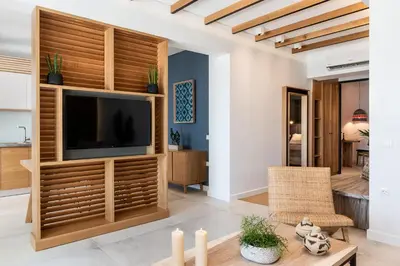 a living room with a television in a wooden entertainment center at Blue Island Luxury Apartment in Kato Daratso