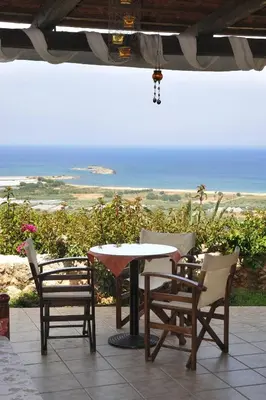a table and chairs with a view of the ocean at Kavousi Resort in Falasarna