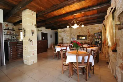 a restaurant with wooden ceilings and tables and chairs at Kavousi Resort in Falasarna