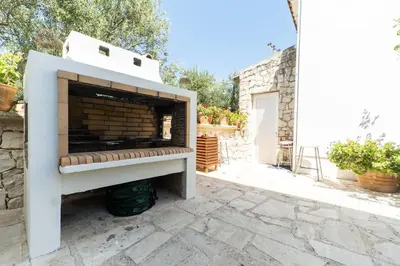 a pizza oven sitting on top of a stone patio at Rodanthi Villas in Darmarochori