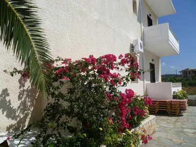 a building with pink flowers on the side of it at Karmi Apartments in Kolymvari
