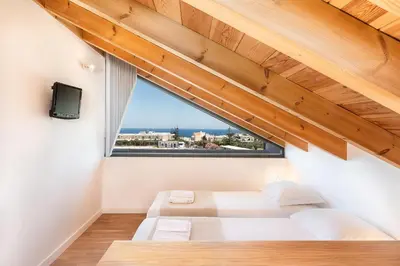 a room with a bed and a window at Fos Villa, a Luxe House with Private Heated Pool in Galatás