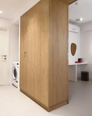 a large wooden door in a room with a washing machine at Fos Villa, a Luxe House with Private Heated Pool in Galatás