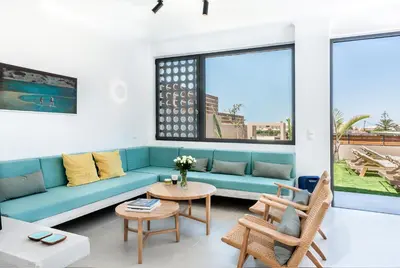 a living room with a blue couch and a table at Fos Villa, a Luxe House with Private Heated Pool in Galatás
