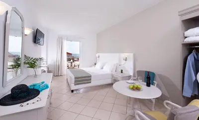 a hotel room with a bed and a table and chairs at Dore Boutique Hotel in Agia Marina Nea Kydonias