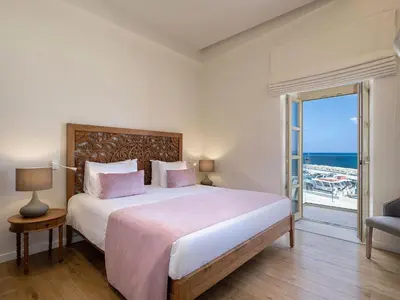 a bedroom with a bed with a view of the ocean at Avra Apartments Kolymbari Harbour in Kolymvari