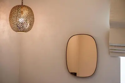 a mirror hanging on a wall with a lamp at Avra Apartments Kolymbari Harbour in Kolymvari