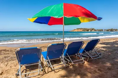 two chairs and an umbrella on a beach at Orama in Kato Daratso