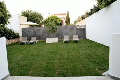 a small backyard with chairs and an umbrella at Orama in Kato Daratso