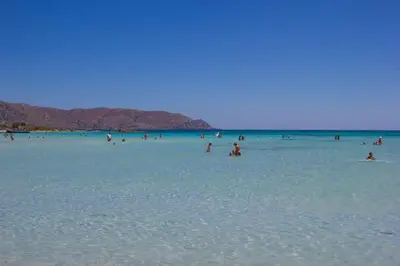 a group of people in the water at the beach at Orama in Kato Daratso