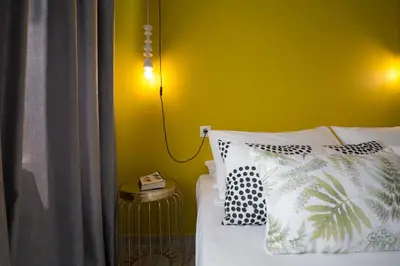 a bedroom with a bed with a yellow wall at Chalepa Boutique Apartment in Chania Town