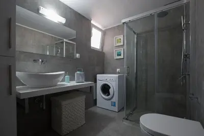 a bathroom with a sink and a washing machine at Chalepa Boutique Apartment in Chania Town