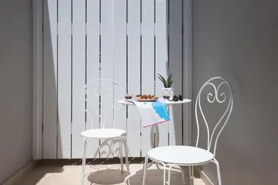 two white chairs and a table with a plate of food at Chalepa Boutique Apartment in Chania Town