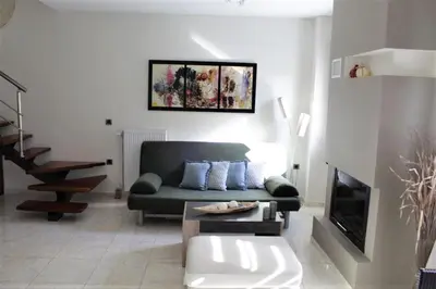 a living room with a couch and a tv at Casa Ariadne in Plataniás