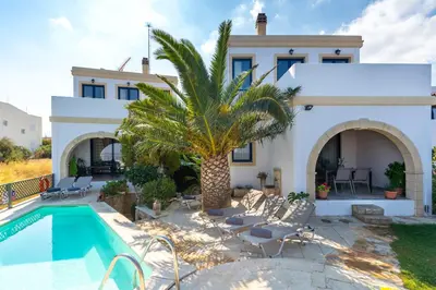 a villa with a swimming pool and a house at Althea Maisonettes in Áptera
