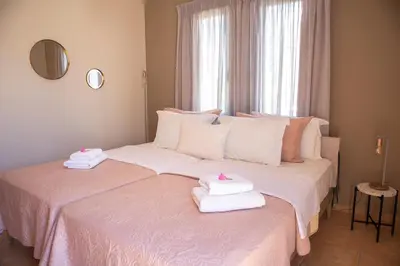 two beds in a room with towels on them at Althea Maisonettes in Áptera