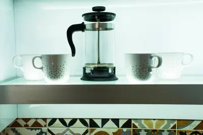 a coffee maker on a shelf with three cups at Elmaya's Duplex in Kissamos