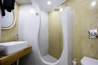 a bathroom with a sink and a shower with a mirror at Elmaya's Duplex in Kissamos