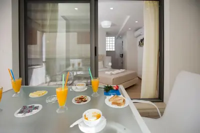 a table with plates of food and orange juice at Elmaya's Duplex in Kissamos