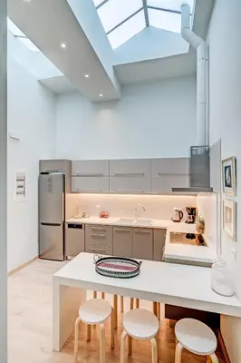 a kitchen with a large white table and stools at Grande Casa 1926 in Chania Town