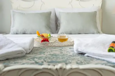a bed with a tray of fruit and a cup of tea at Grande Casa 1926 in Chania Town