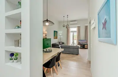 a dining room and living room with a table and chairs at Grande Casa 1926 in Chania Town