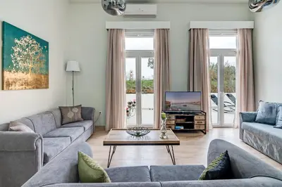 a living room with two couches and a tv at Grande Casa 1926 in Chania Town