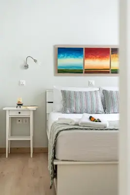 a white bedroom with a bed and a table at Casa 1926 in Chania Town