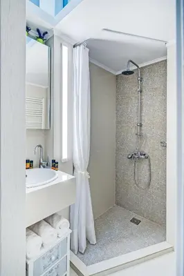 a white bathroom with a shower and a sink at Casa 1926 in Chania Town