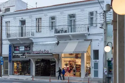 a white building with people walking in front of it at Casa 1926 in Chania Town