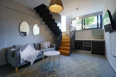 a living room with a couch and a staircase at 3 bdr apartment 5 km from the city in Agios Onoufrios