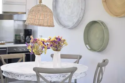a dining room table with flowers and plates on the wall at 3 bdr apartment 5 km from the city in Agios Onoufrios