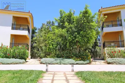 a park in front of a building with a tree at Monachus Monachus in Frangokastello