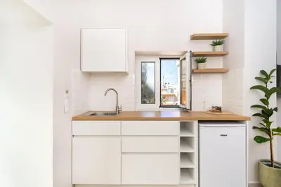 a white kitchen with a sink and a window at Camara Residence in Chania Town